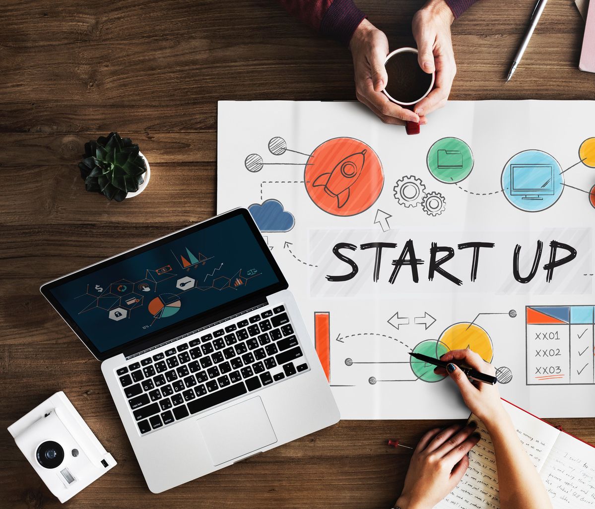 Startup planning desk with laptop and illustrated workflow